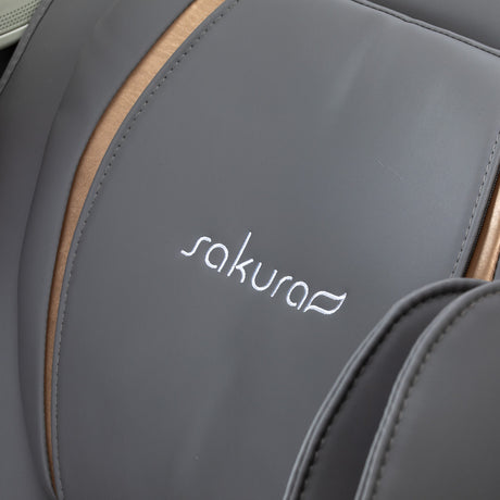 White and grey Sakura 3D Maximus massage chair with padded armrests and sleek design, perfect for relaxation and comfort.