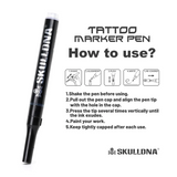 Blue SKULL DNA tattoo marker pen by AVA, showing a close-up of the precision tip with skull and DNA design on the pen body.